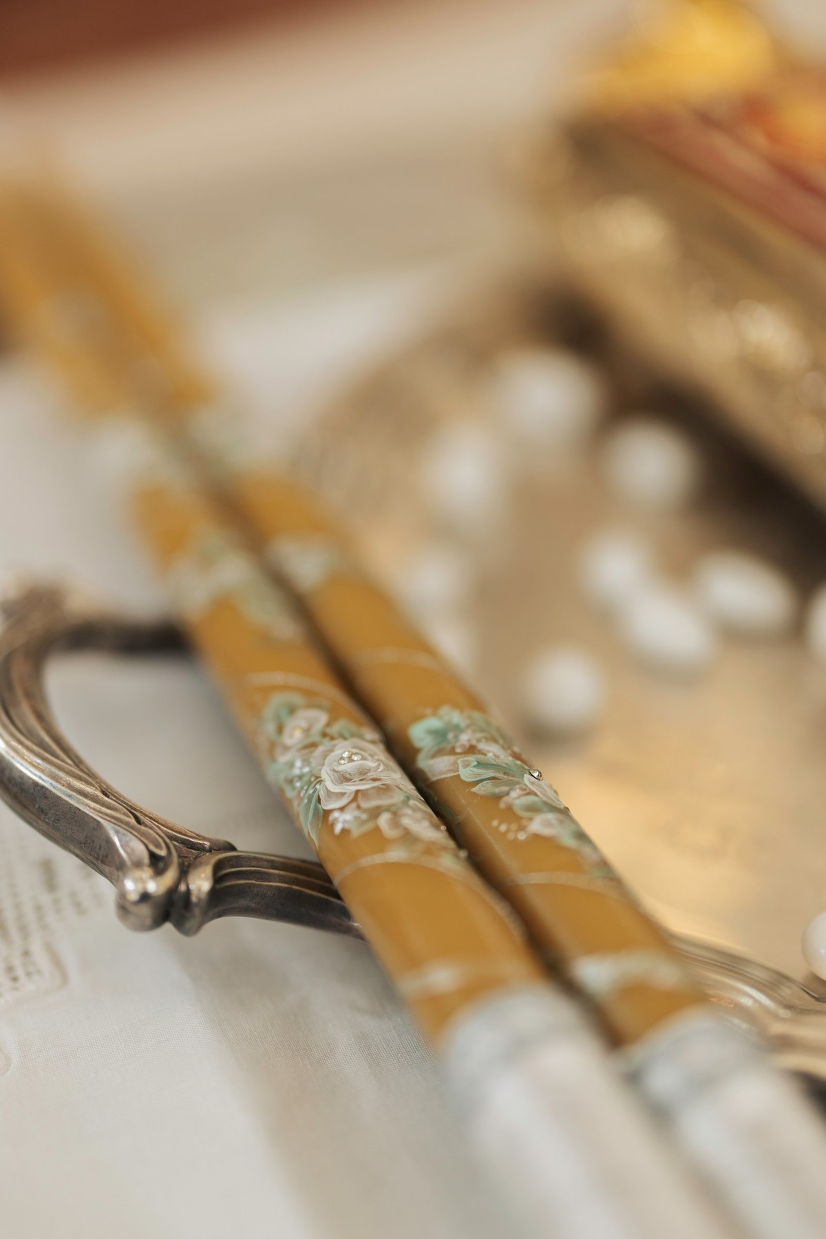 Decorated wedding candles resting beside the service books