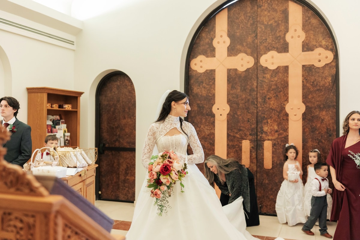 The bride waits with children beside the center aisle