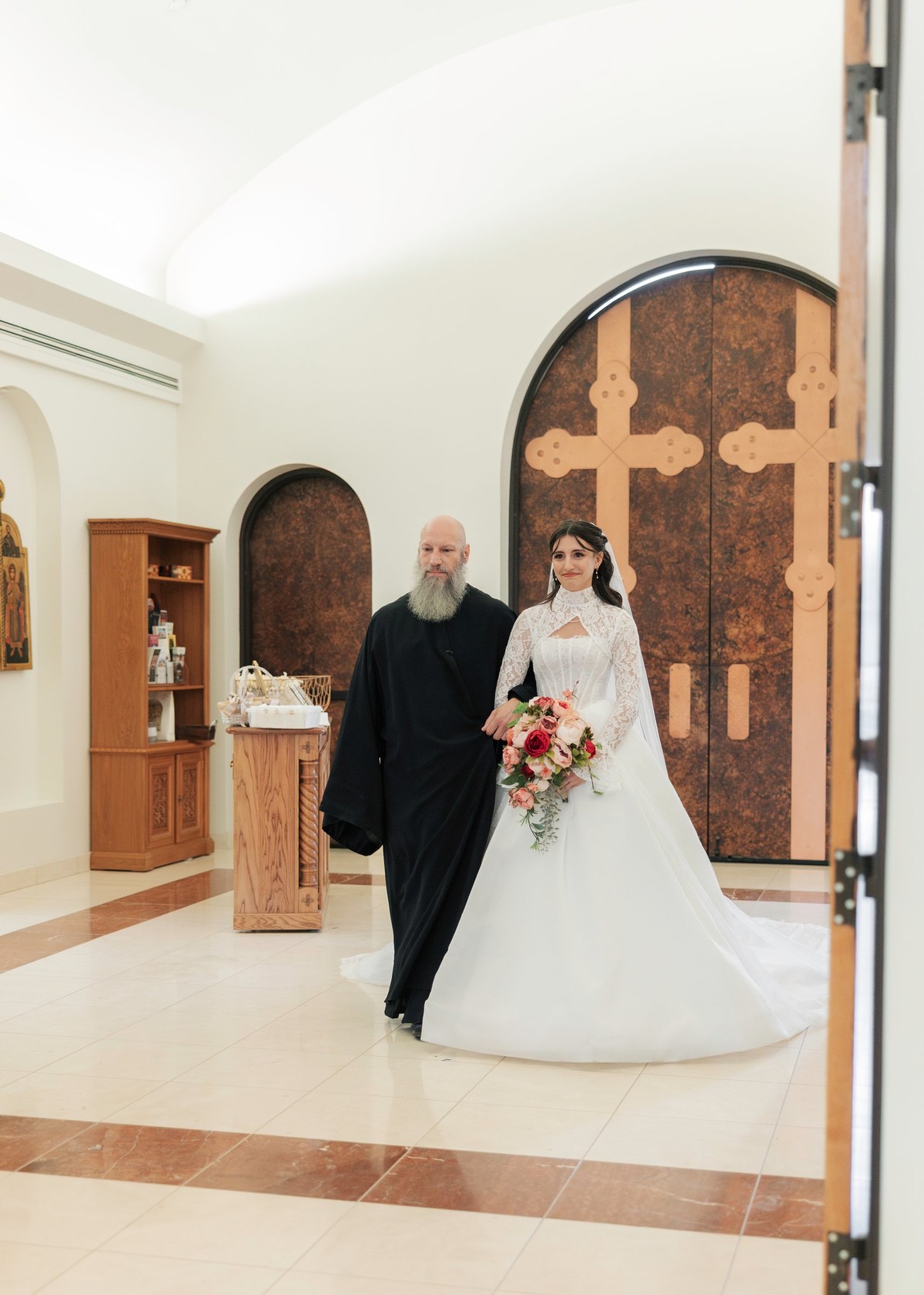 The bride enters the church with an older man