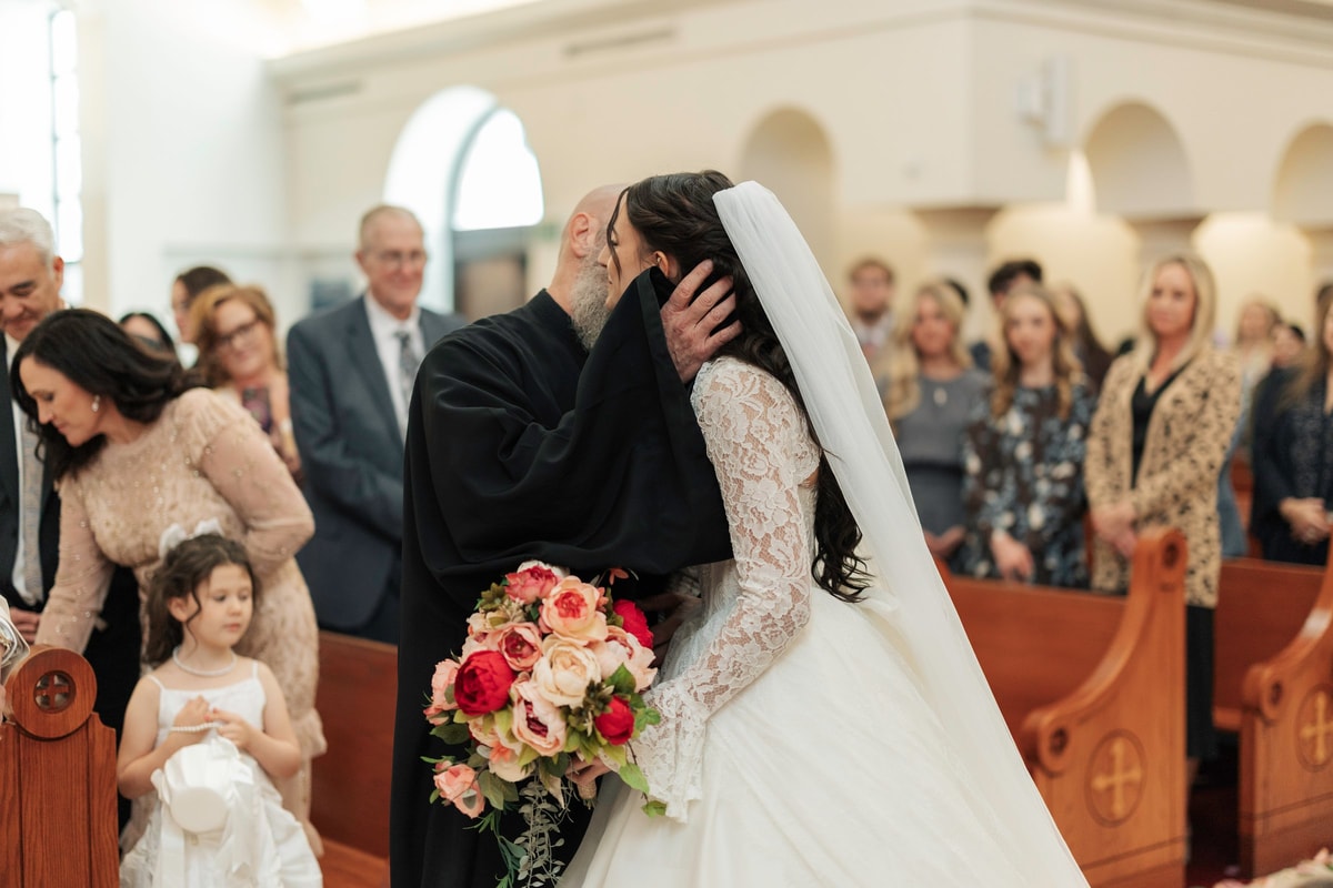 The bride greets guests beside the aisle