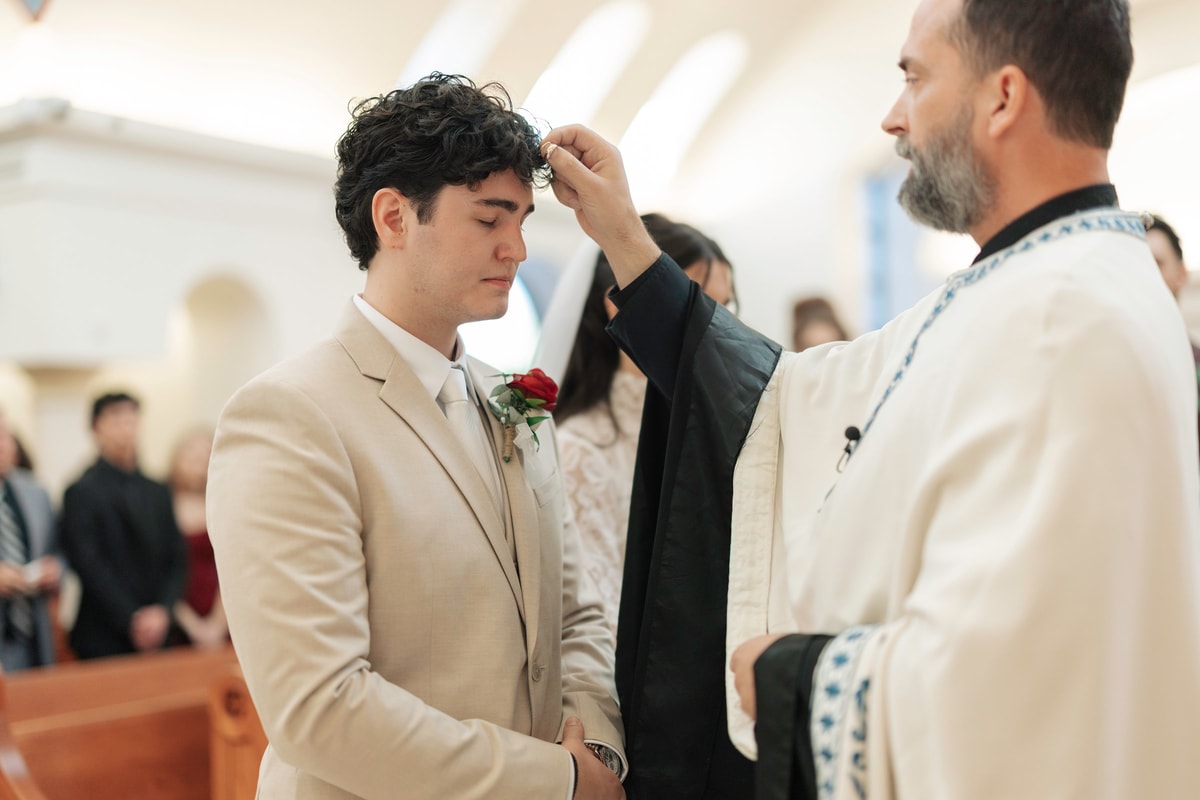 An Orthodox priest blesses the groom during the wedding service