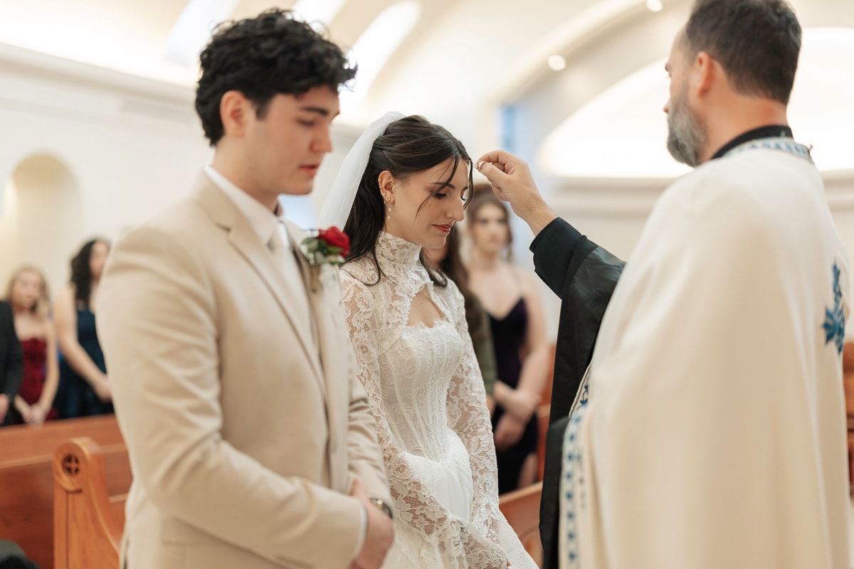 An Orthodox priest blesses the bride during the wedding service