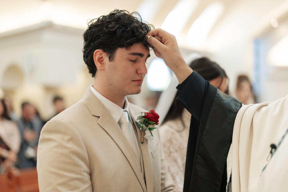 An Orthodox priest blesses the groom during the wedding service