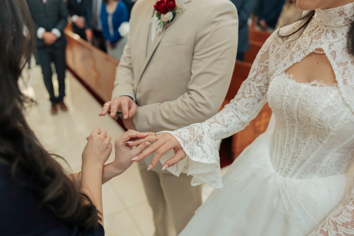 A wedding ring is placed on the bride's hand