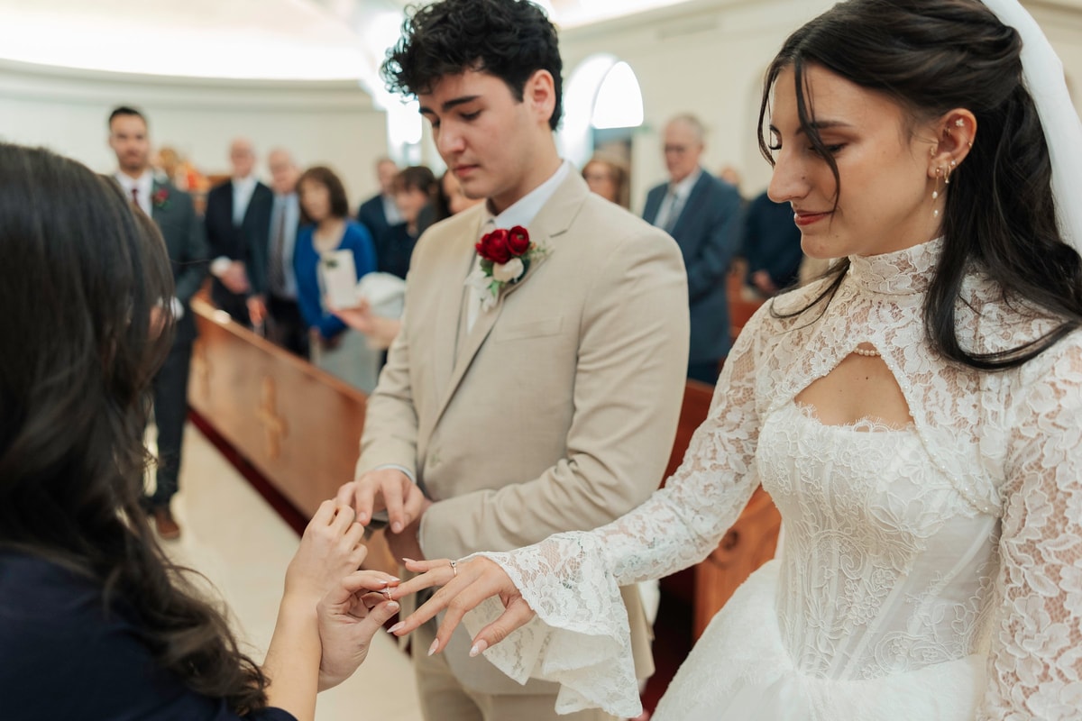 A wedding ring is placed on the bride's hand