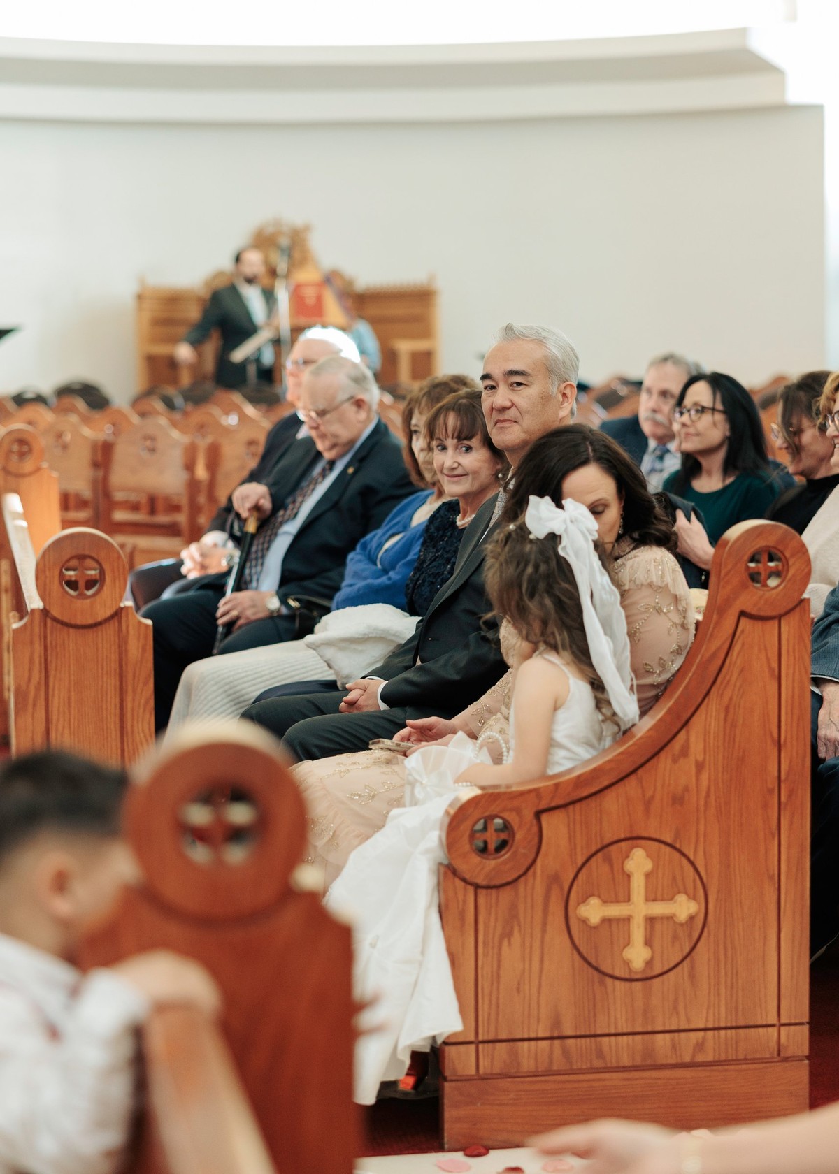 A child watches the wedding ceremony from a pew