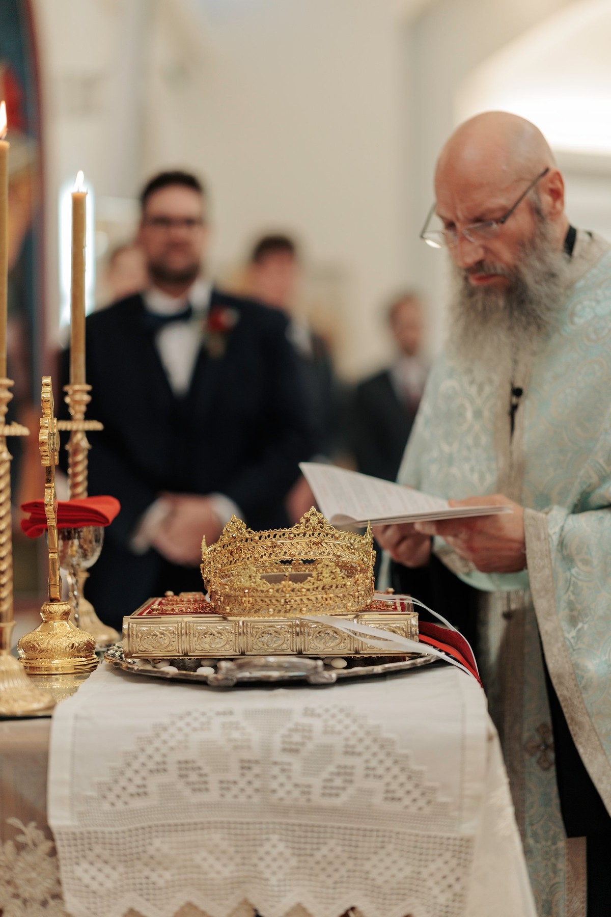 A priest reads prayers over the wedding crowns on the tetrapod
