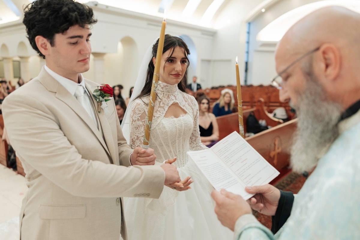 The priest joins the couple's hands during the service