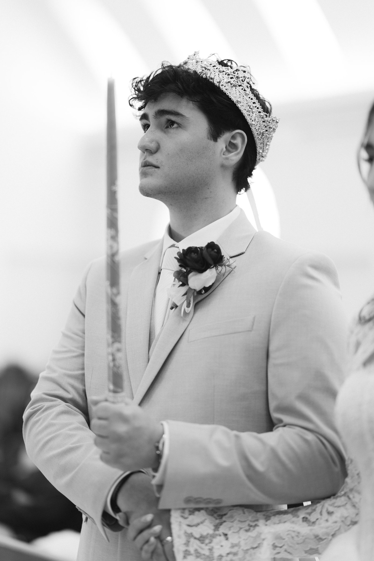 The groom wears his wedding crown in a black-and-white portrait