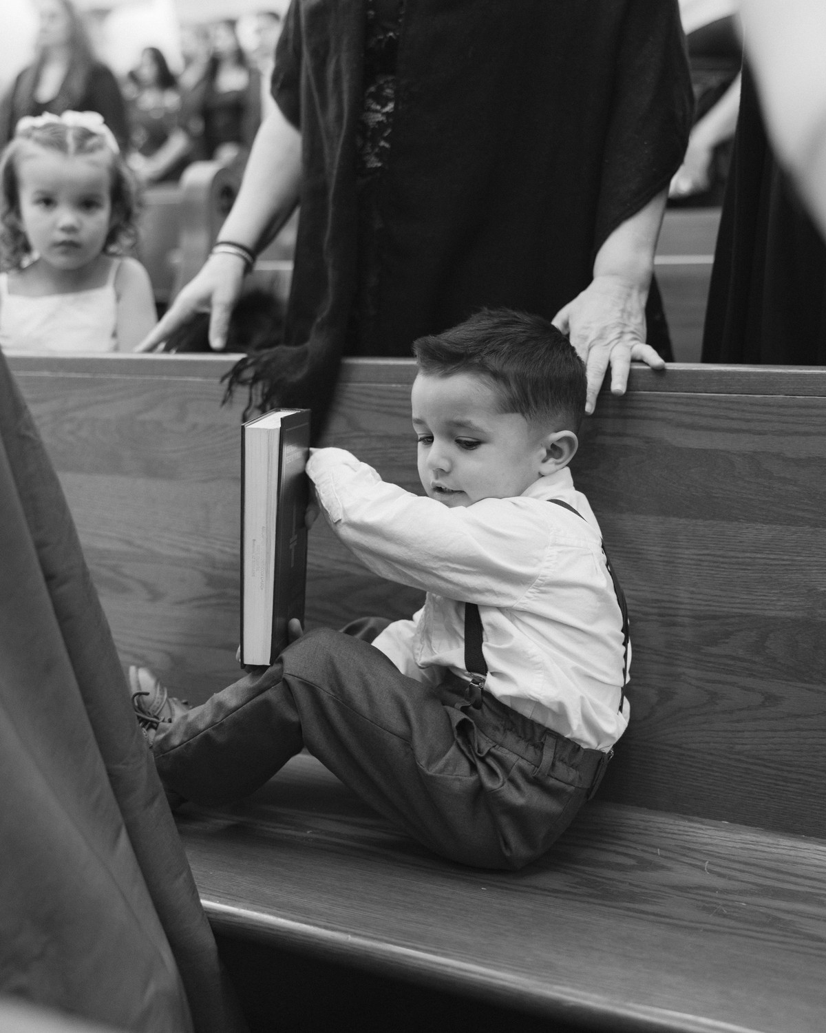 A child climbs onto a pew during the service in a black-and-white photograph