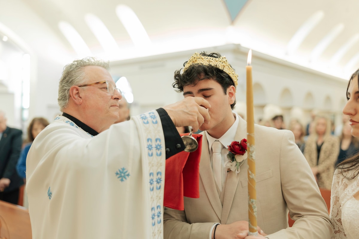 The groom receives the common cup from the priest