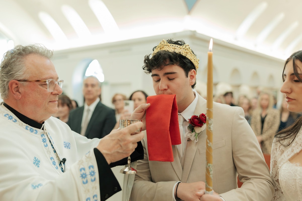 The groom receives the common cup from the priest