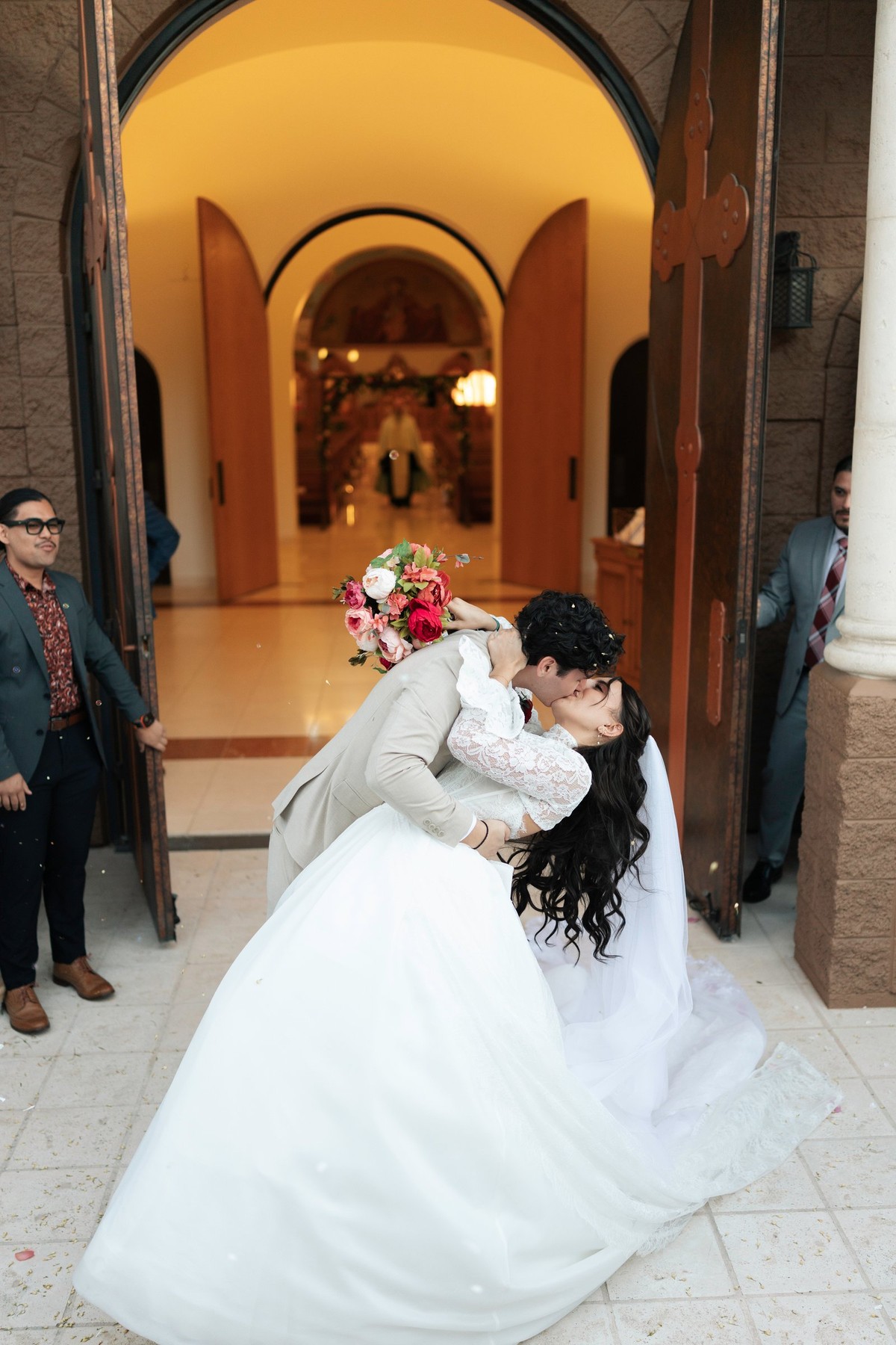 The groom dips the bride outside the church doors
