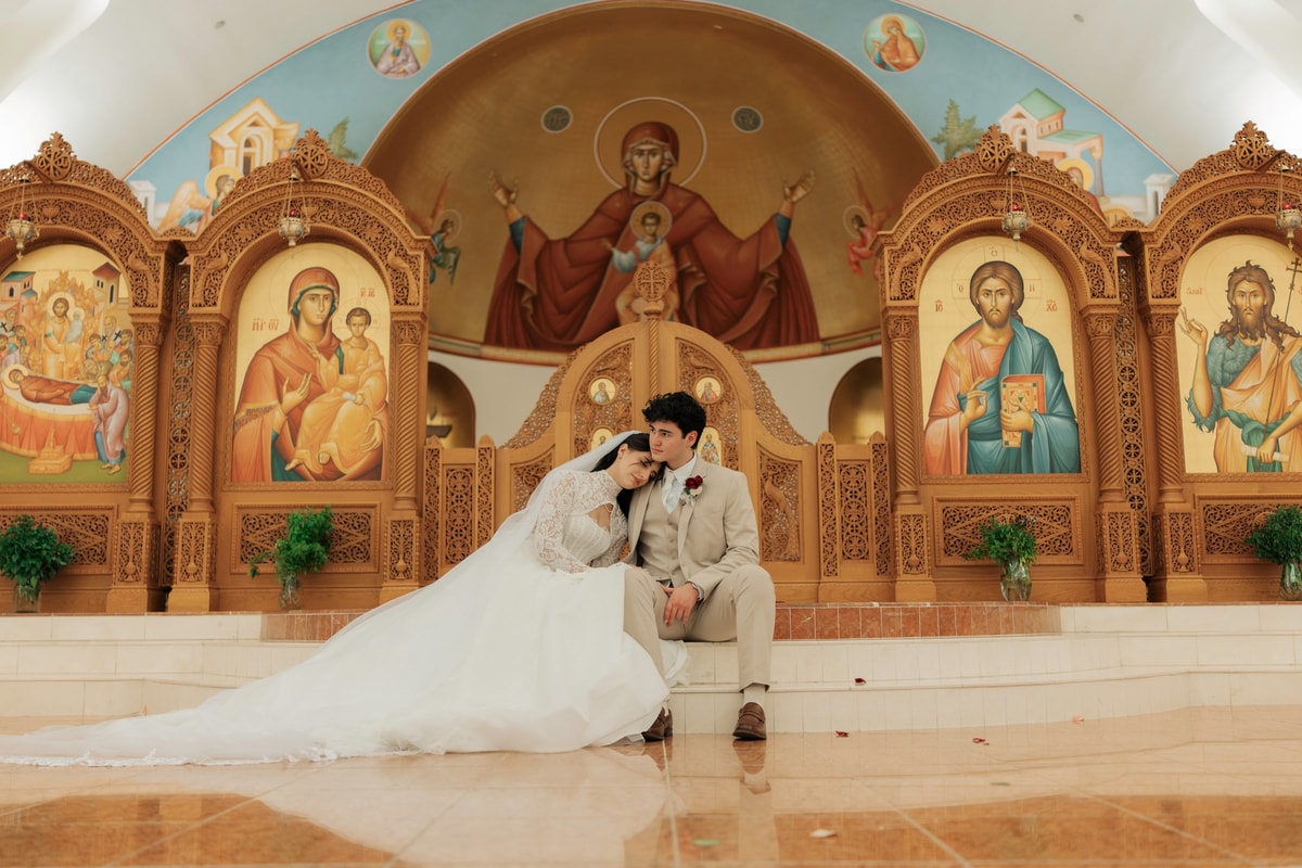 The bride and groom sit together for a portrait inside the church
