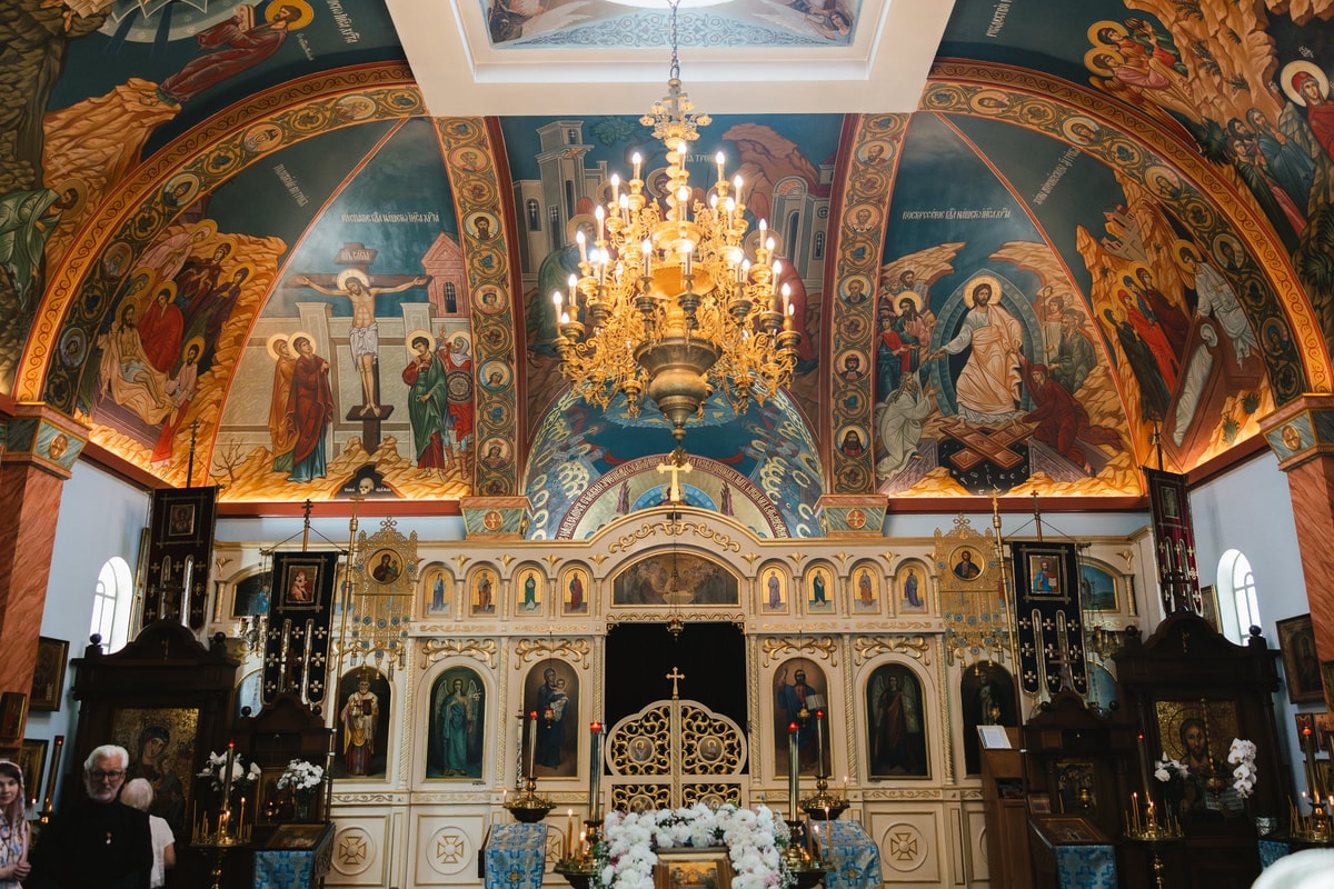 A painted iconostasis and chandelier inside an Orthodox church