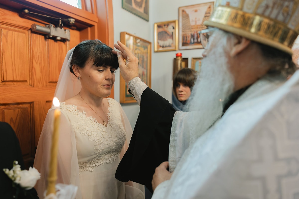 A bishop blesses the bride at the church entrance