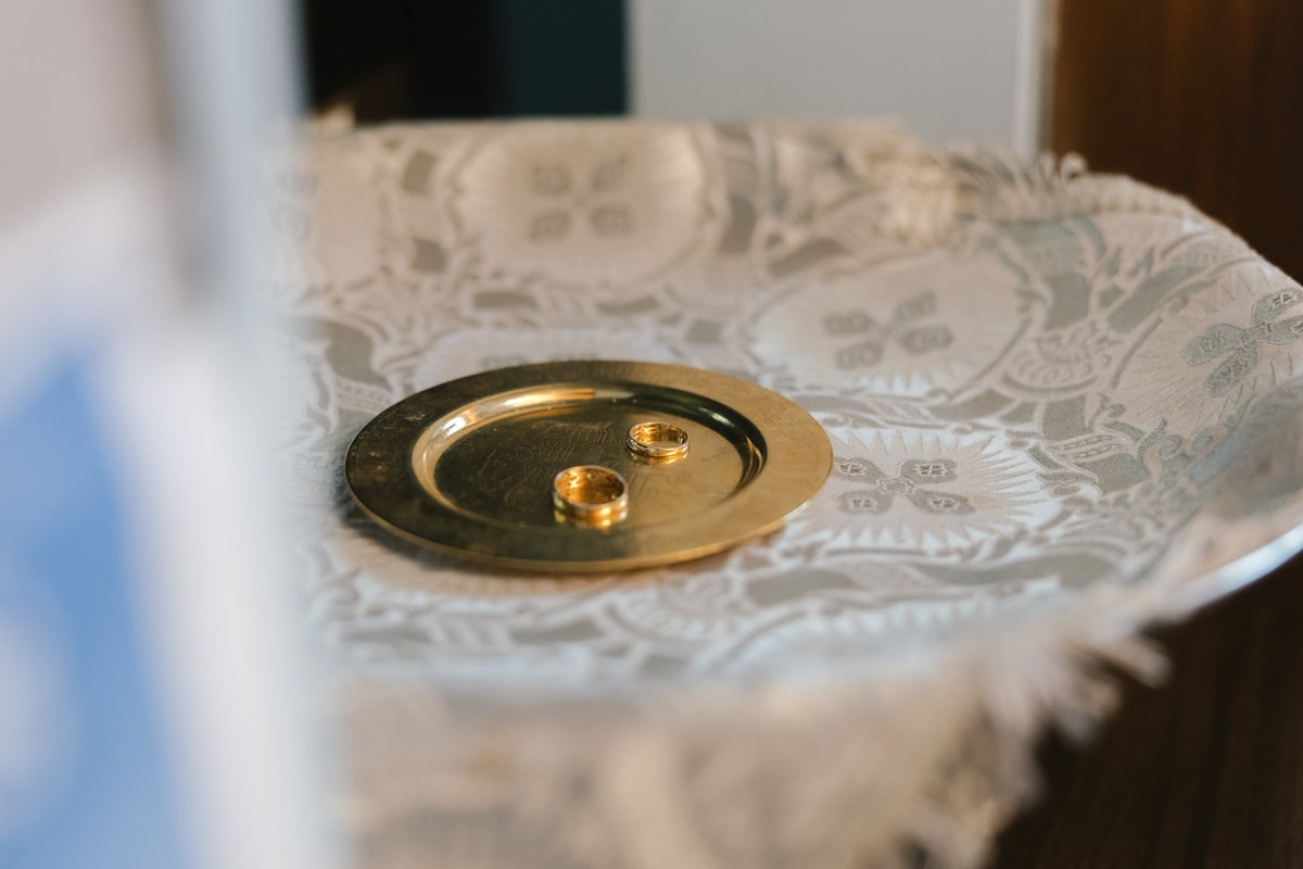 The wedding rings resting in a small gold dish