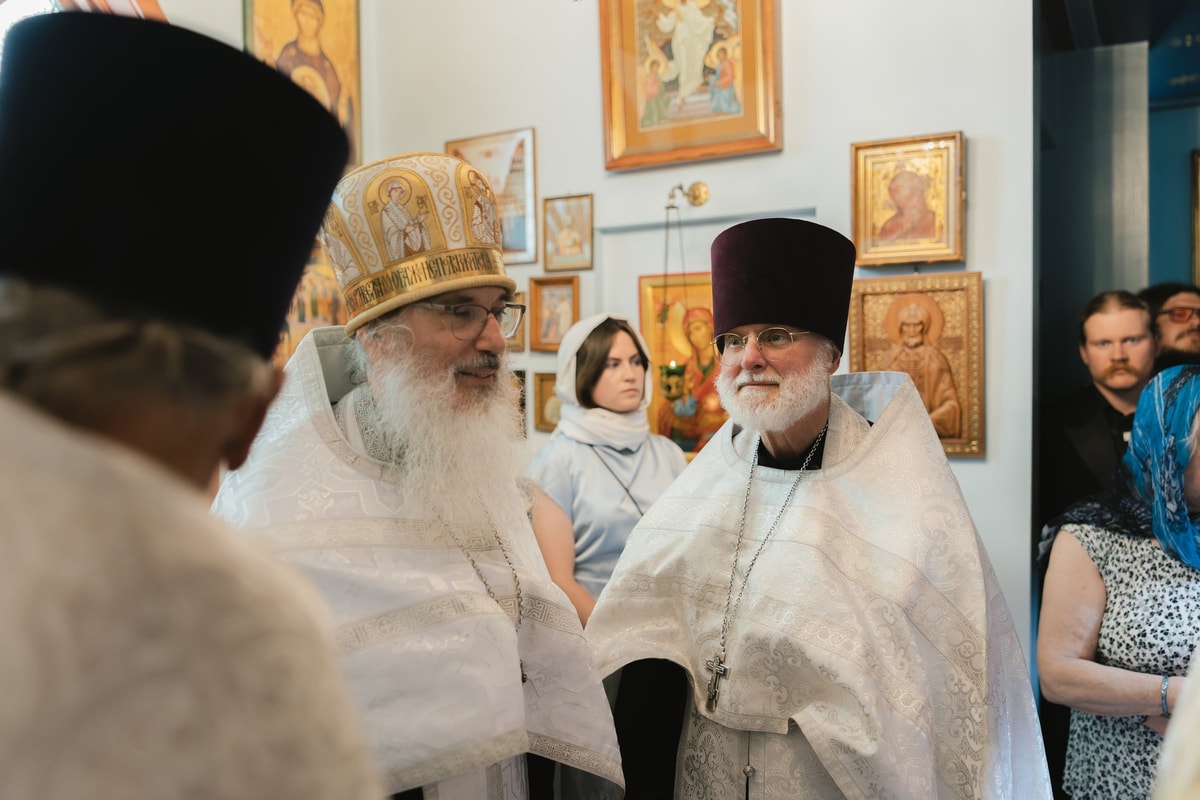 The bride and groom face the clergy at the church entrance