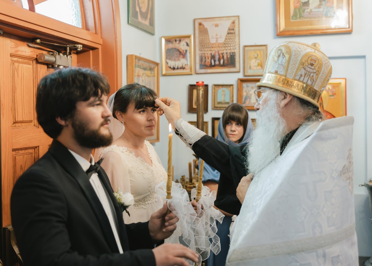 A bishop blesses the groom during the wedding service