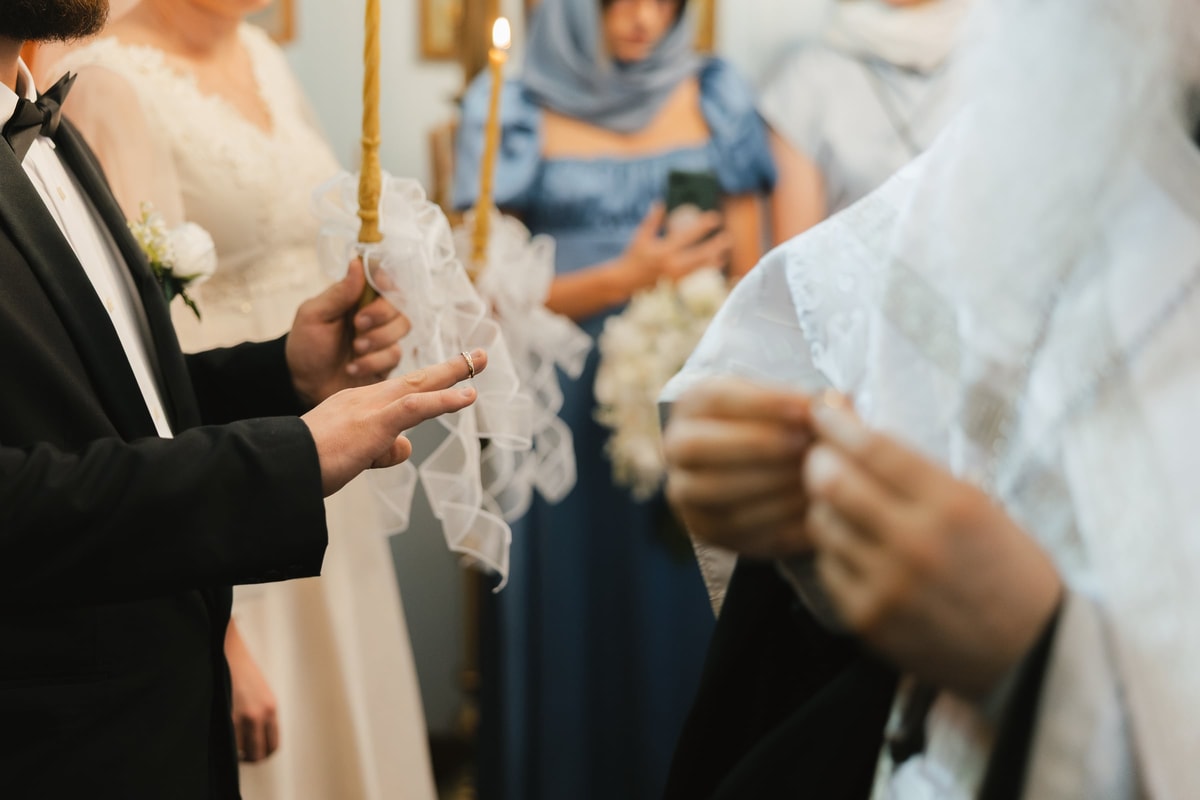 The wedding rings are exchanged on the couple's hands