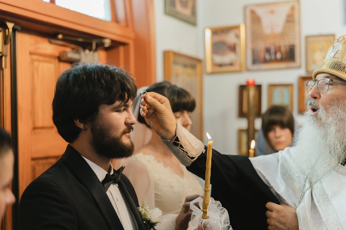 A bishop blesses the groom on the forehead
