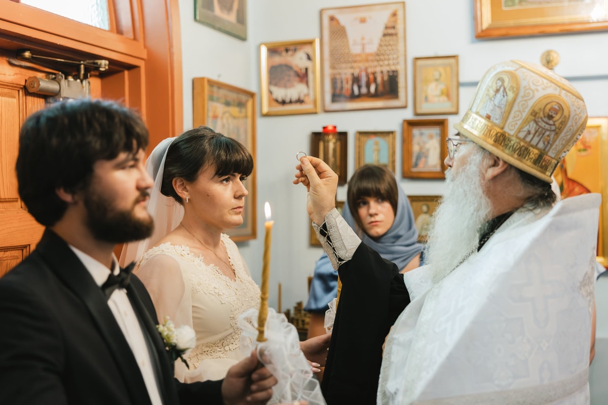 A bishop blesses the bride on the forehead