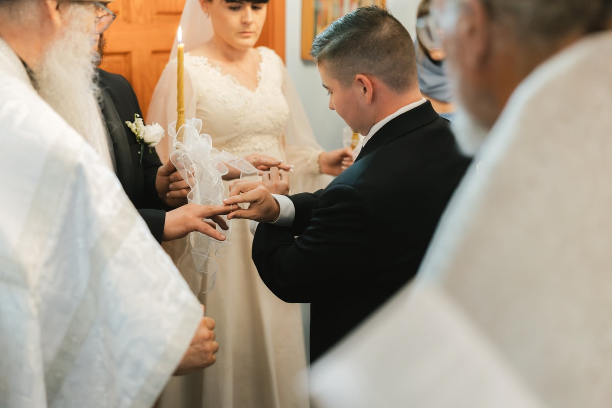 Wedding rings are exchanged on the couple's hands