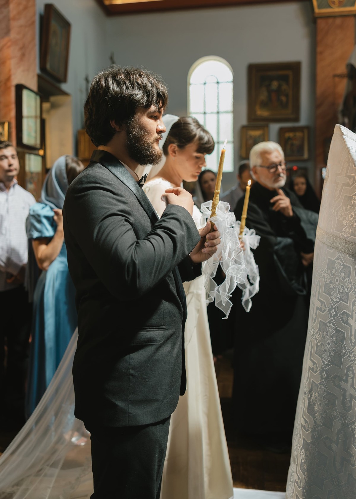 The groom makes the sign of the cross during the service