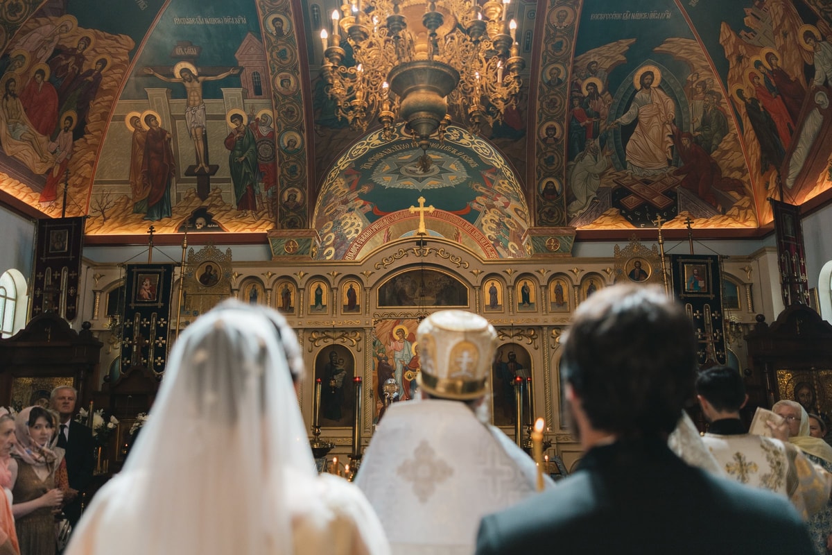 A wedding service beneath a painted ceiling and chandelier