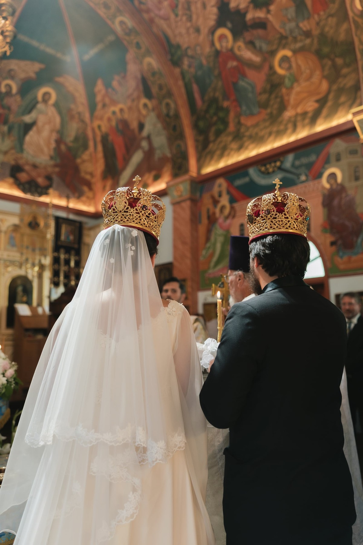 An Orthodox priest leads a crowned bride and groom in the wedding procession