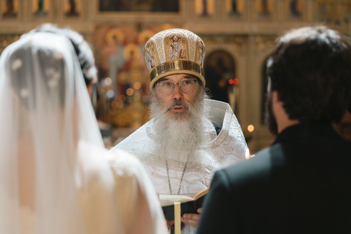 The bishop addresses the kneeling couple
