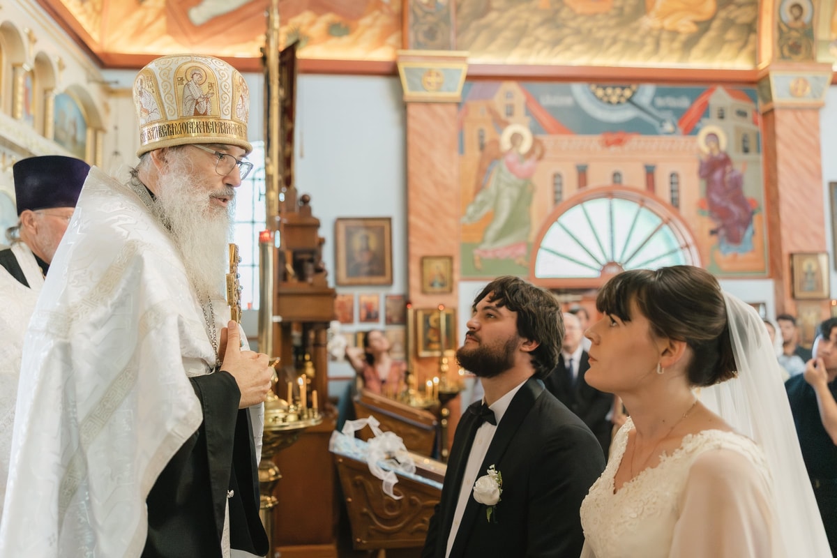 The groom kneels before the bishop