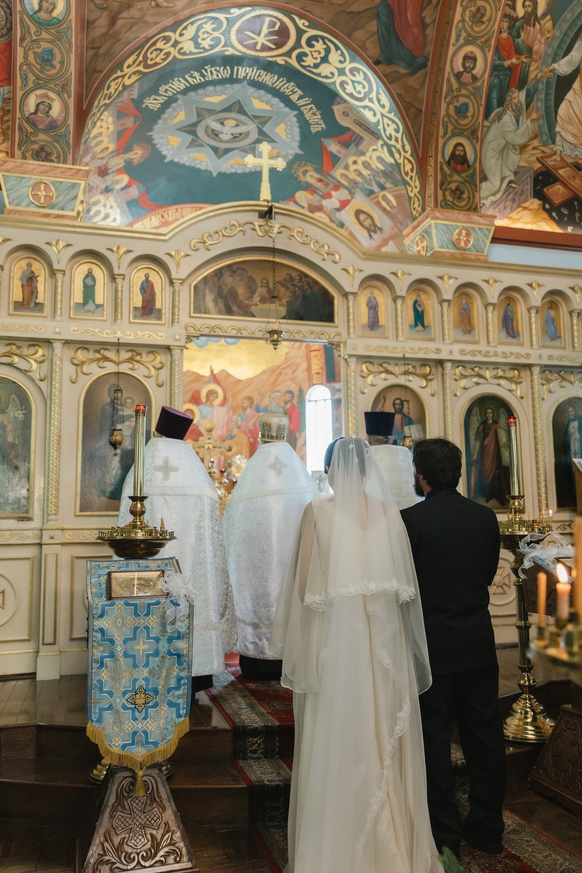 The newly married couple faces the iconostasis