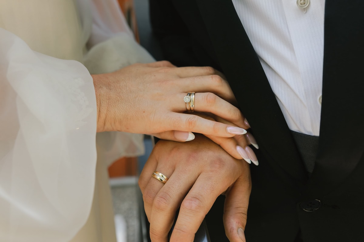 The couple's hands showing their wedding rings