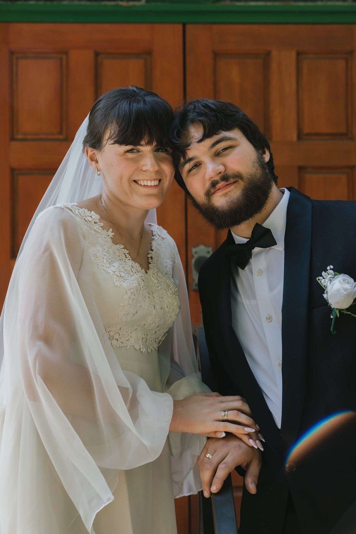 The bride and groom smile together outside the church