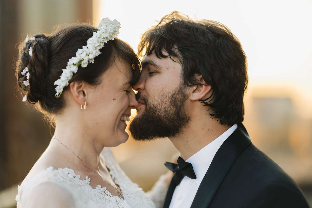 The bride and groom smile with their faces close together
