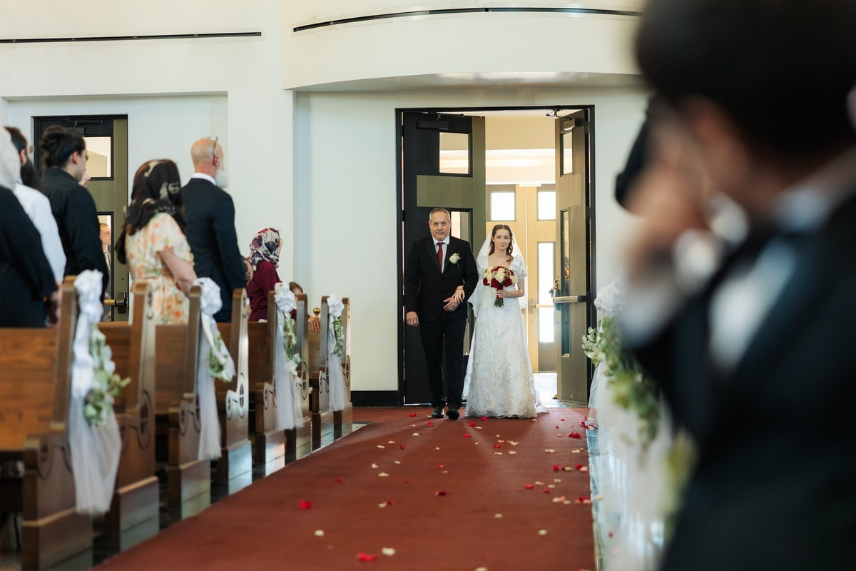 A bride enters an Orthodox church with her escort