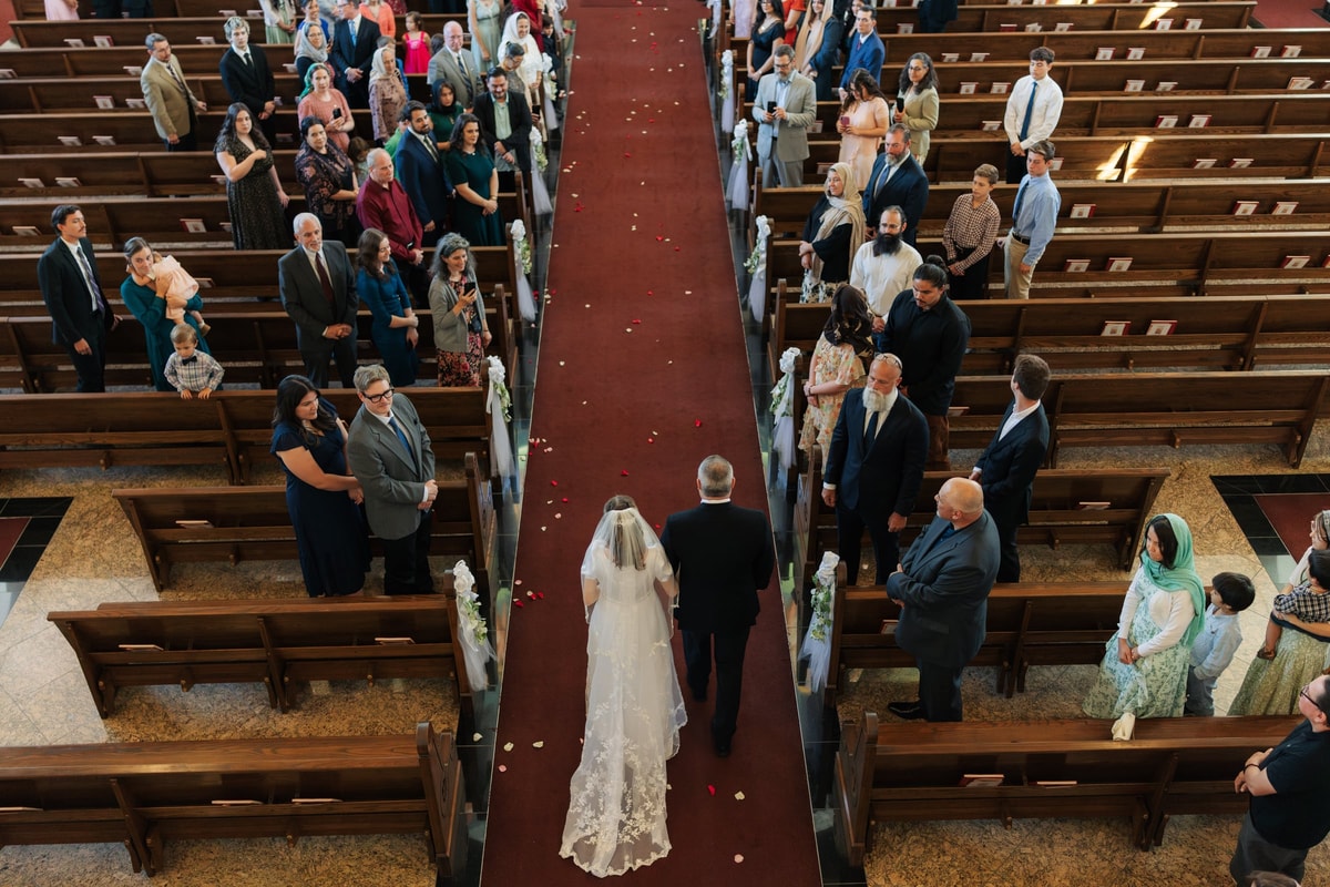 A bride enters an Orthodox church with her escort