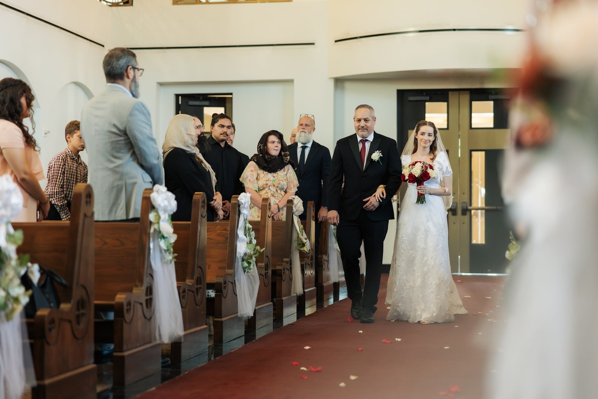 A bride enters an Orthodox church with her escort