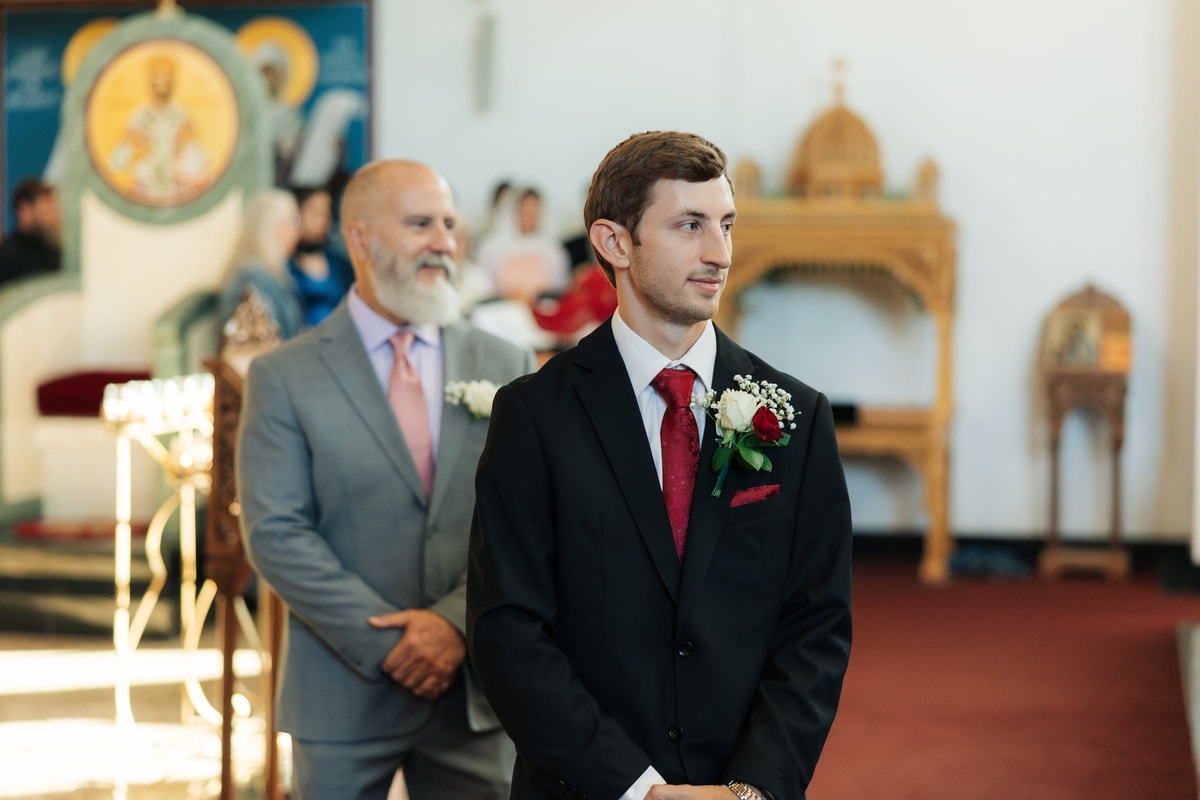 The groom waits at the front of the church