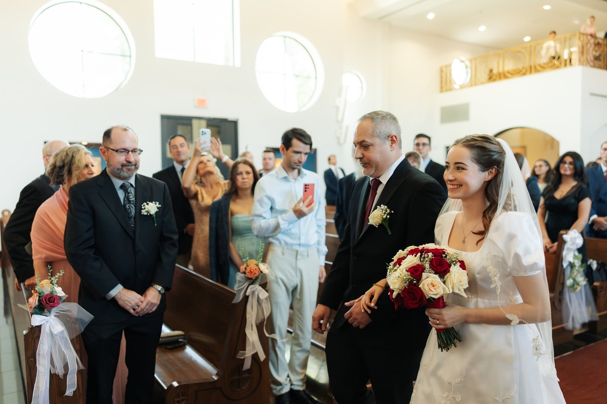 The bride reaches the front of the church with her escort