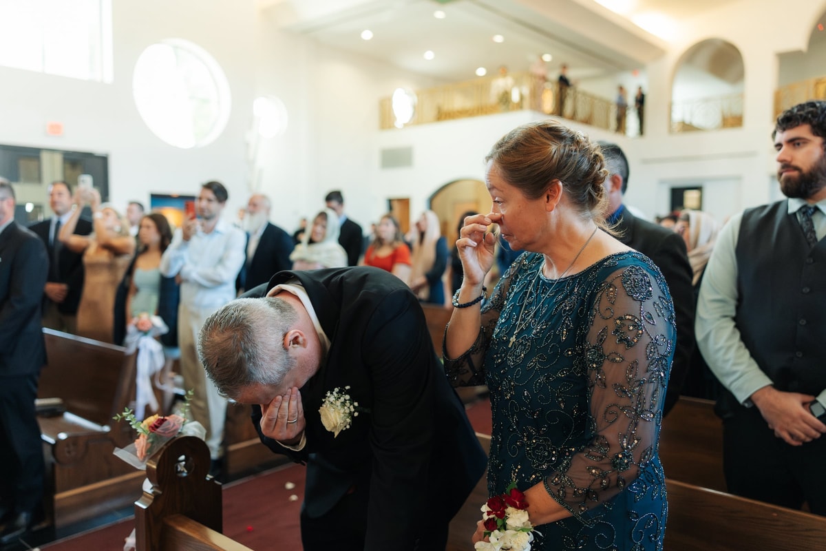 Guests embrace before the wedding service