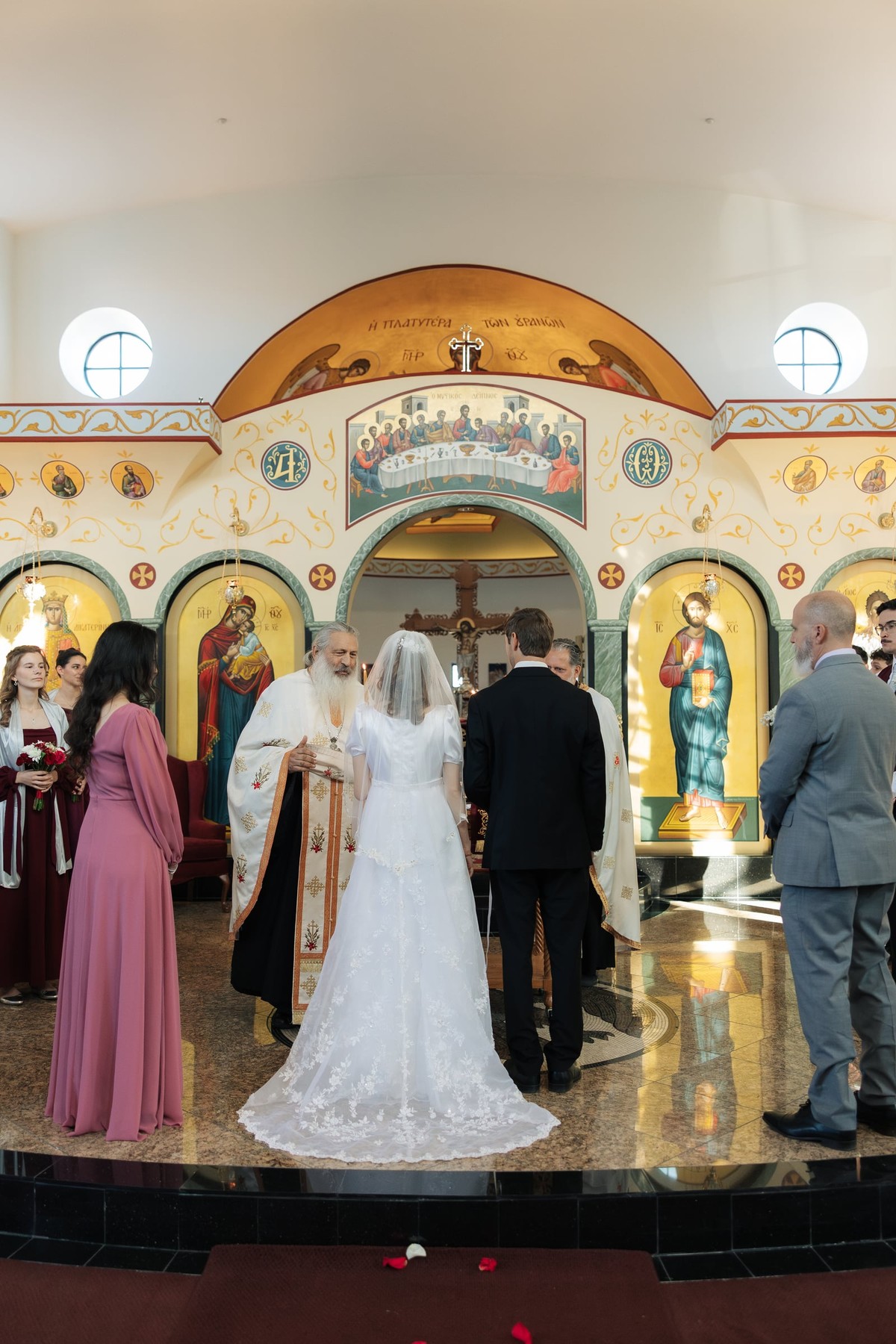The bride and groom stand before the priest at the start of the ceremony