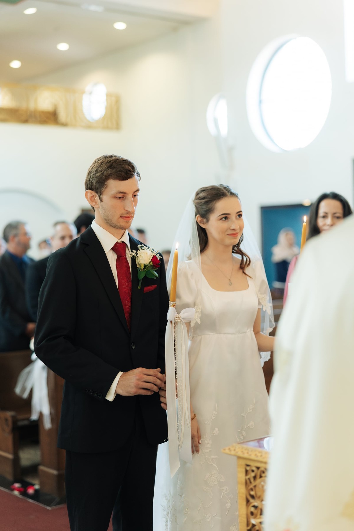 The bride and groom stand before the priest at the start of the ceremony