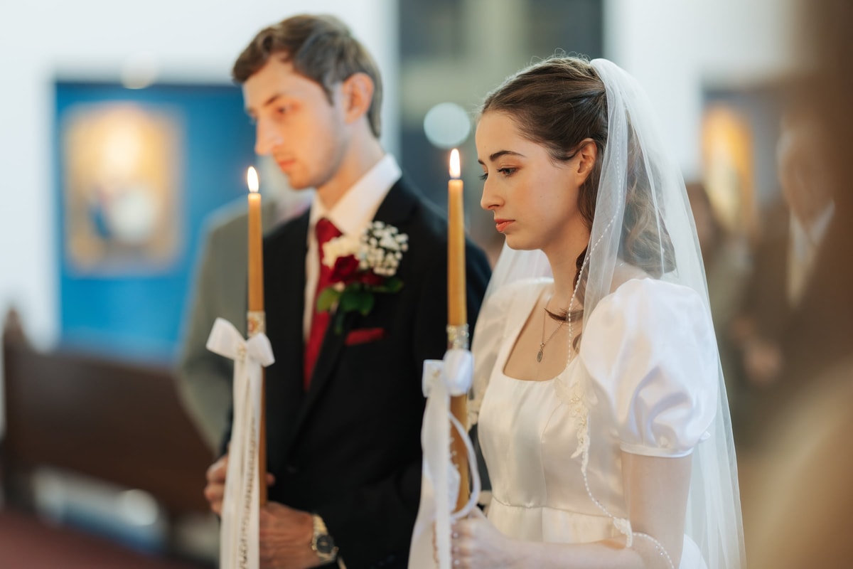 The bride and groom hold lighted wedding candles