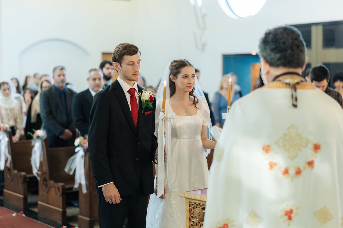 The bride and groom face the priest during the service