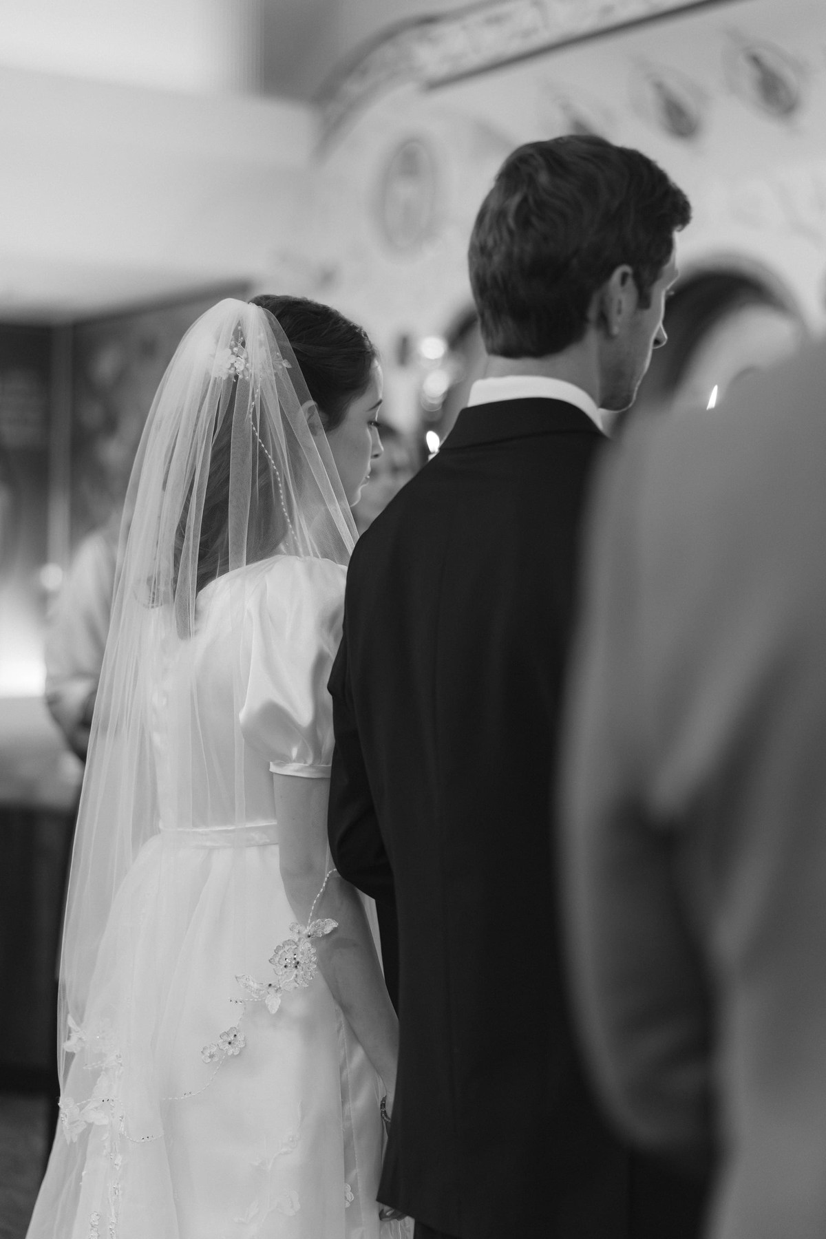 The bride and groom listen to the priest during the marriage prayers