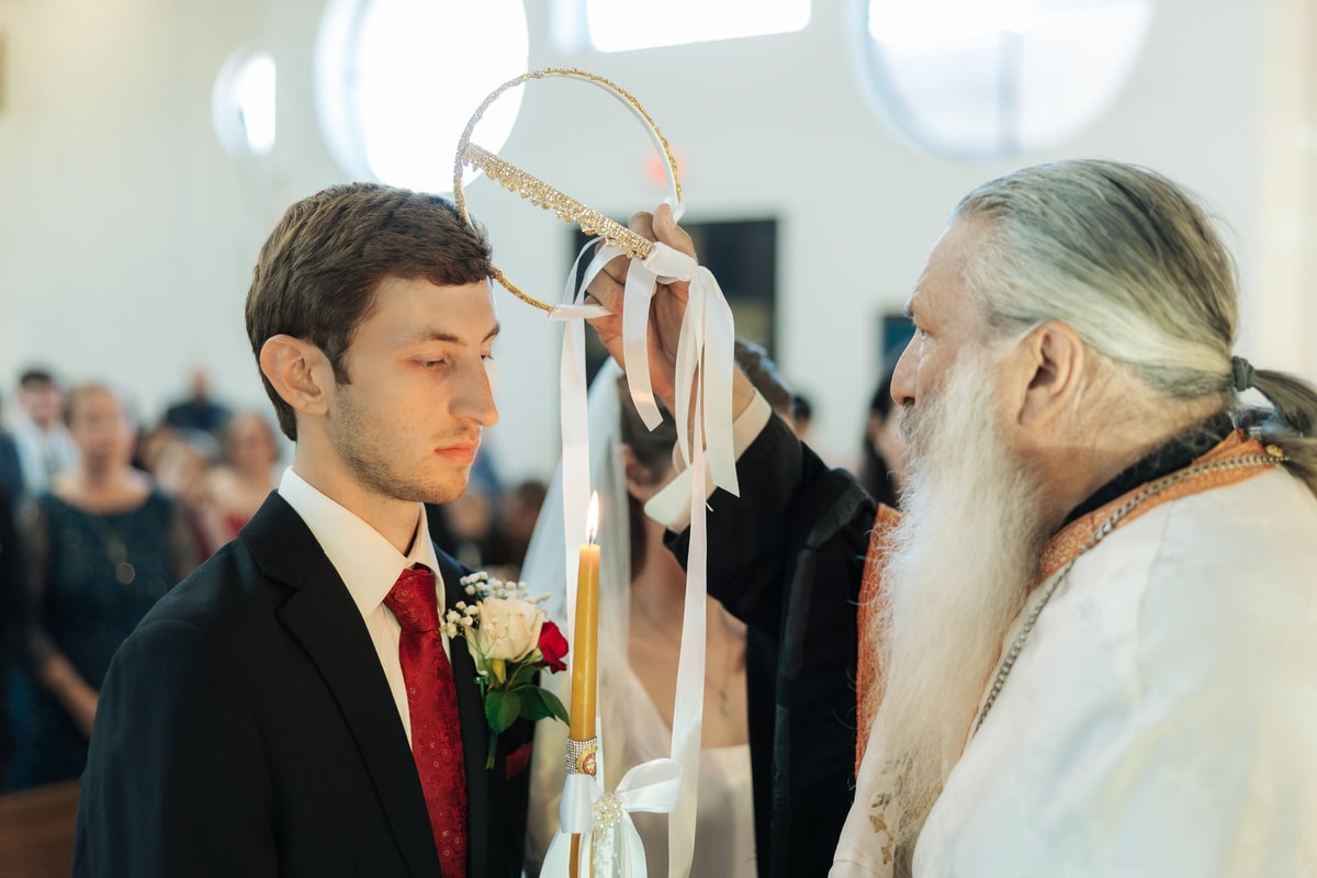 The wedding crowns are exchanged above the bride and groom