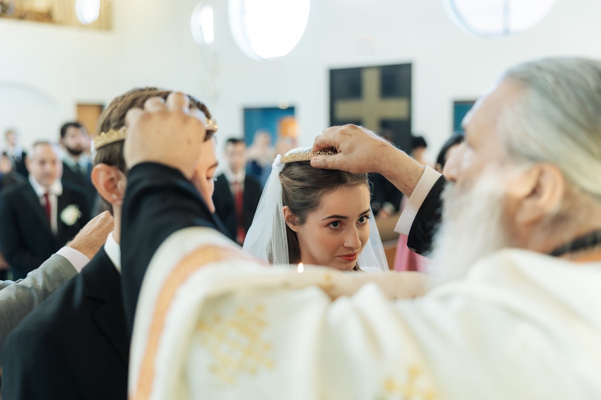 A priest places the bride's wedding crown on her head