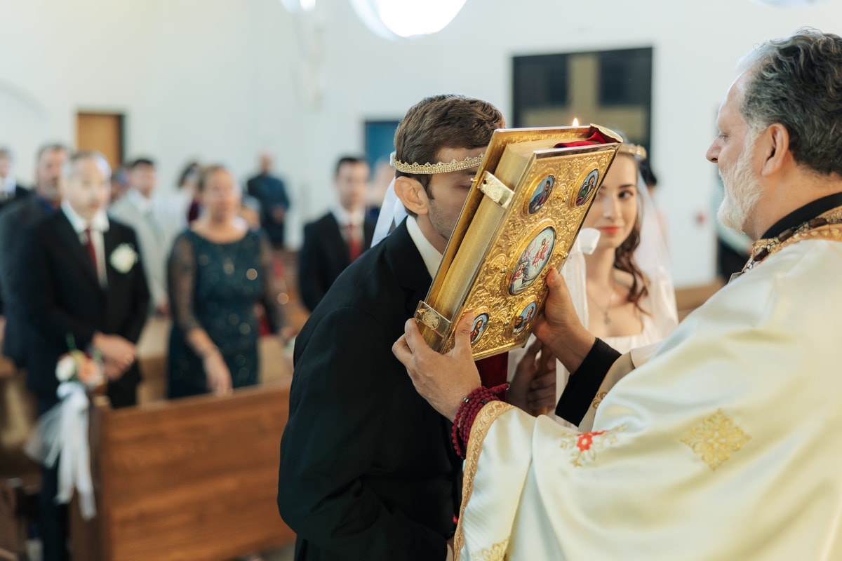 The groom kisses the Gospel book at the close of the service